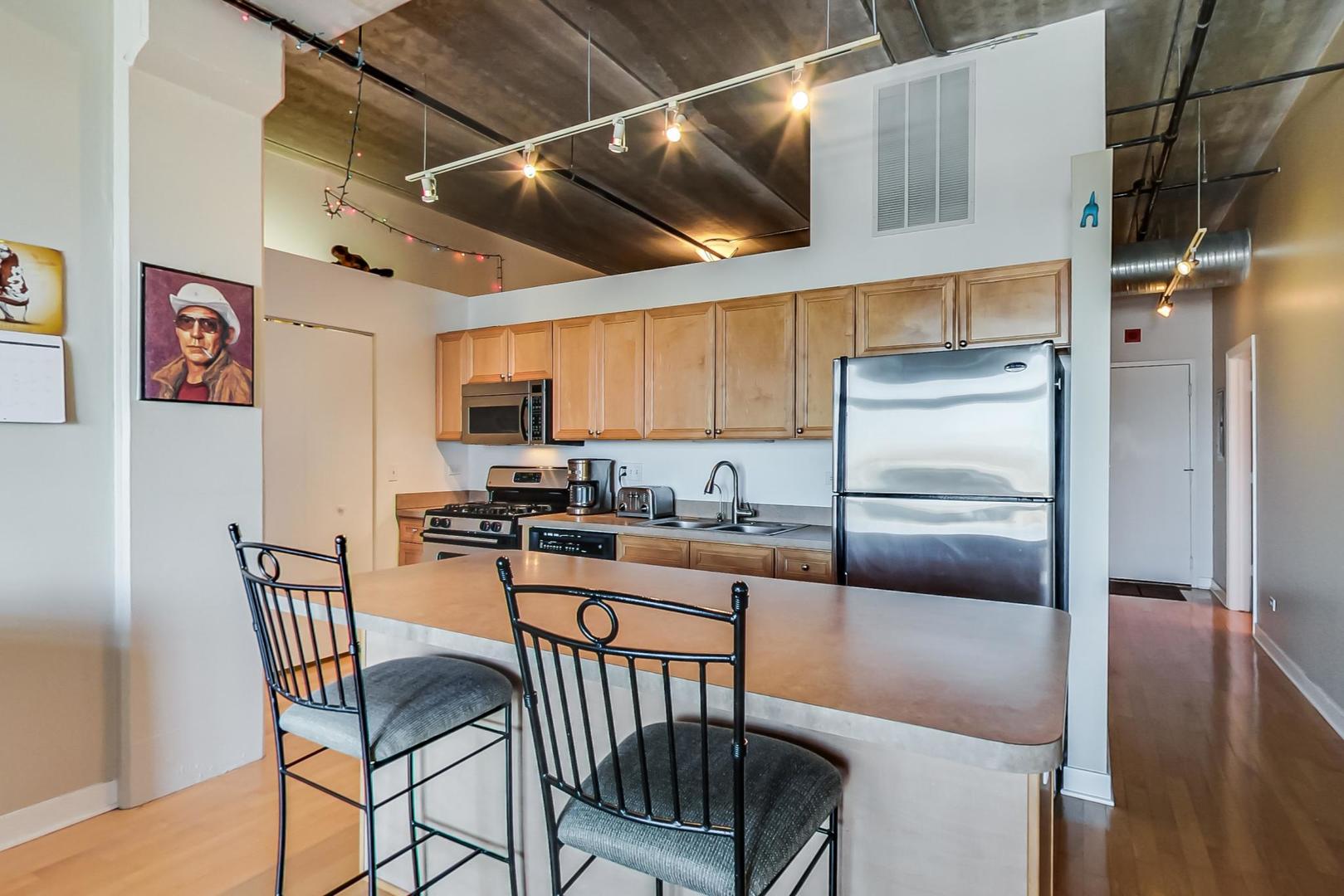 811 West 15th Place, Unit 606 Chicago, IL 60608 - Photo 6 of 22 a kitchen with stainless steel appliances granite countertop a refrigerator a stove top oven a sink and dishwasher