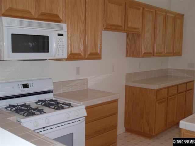 10561 Eagle Falls Way Reno, NV 89521 - Photo 5 of 13 a kitchen with granite countertop cabinets and a stove top oven