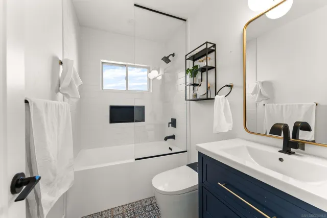 a bedroom with a bed chandelier and a window