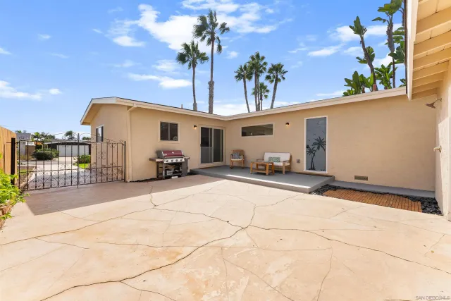 a backyard of a house with table and chairs
