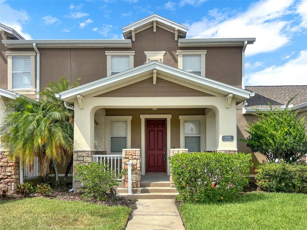 a front view of a house with a yard and potted plants
