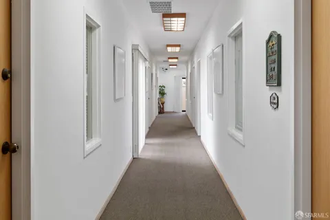 a view of a hallway with windows and closet