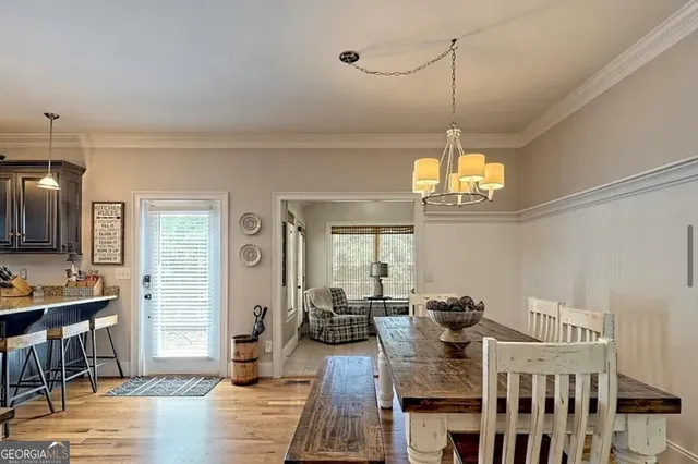 a view of a dining room and livingroom with furniture wooden floor a chandelier