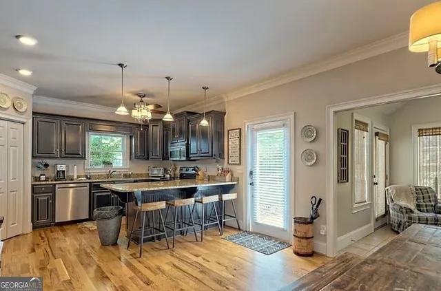a kitchen with stainless steel appliances kitchen island granite countertop a sink stove and refrigerator