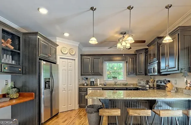 a kitchen with stainless steel appliances granite countertop a sink refrigerator and cabinets