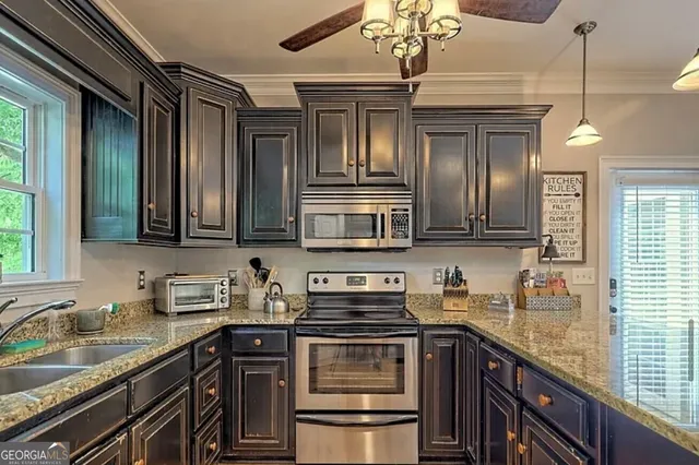 a kitchen with stainless steel appliances granite countertop a sink stove and cabinets