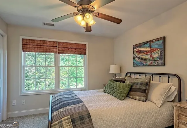 a bedroom with a bed and a painting on the wall