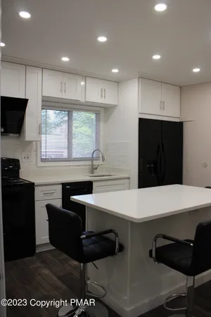 a kitchen with stainless steel appliances kitchen island granite countertop a stove a sink and a refrigerator