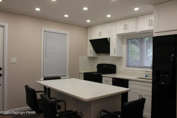 a kitchen with a table chairs refrigerator and microwave