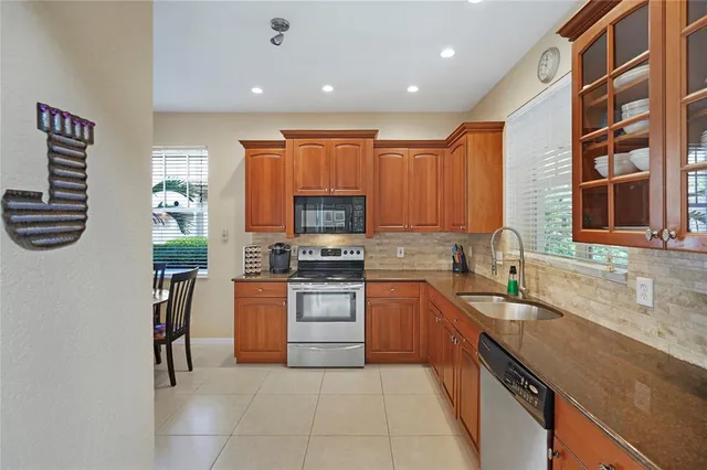 a kitchen with stainless steel appliances granite countertop a refrigerator and a stove top oven