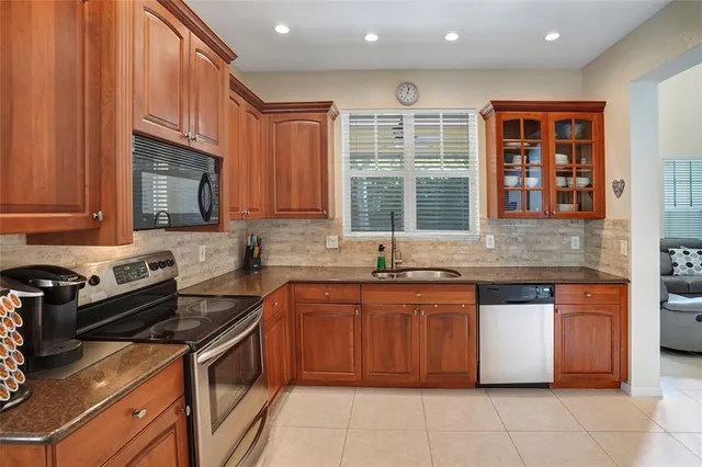 a kitchen with stainless steel appliances granite countertop a stove sink and cabinets