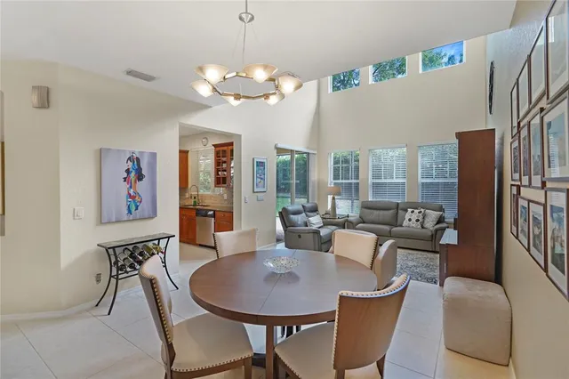 a view of a dining room with furniture a chandelier and wooden floor