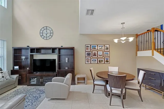 a living room with furniture a flat screen tv and a chandelier