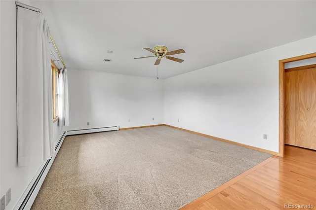 an empty room with window and ceiling fan
