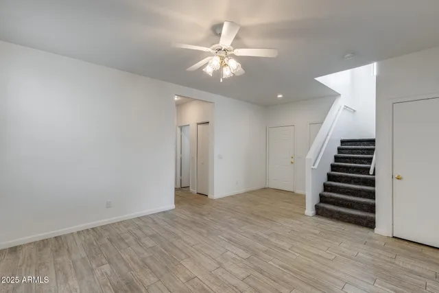 wooden floor in an empty room with a ceiling fan
