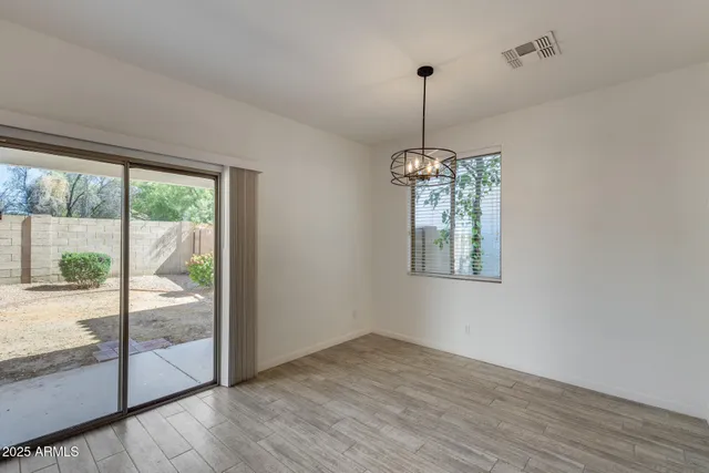 a hallway with a chandelier wooden floor and windows