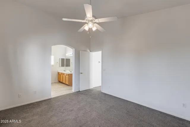 a very nice looking room with a ceiling fan and bathroom
