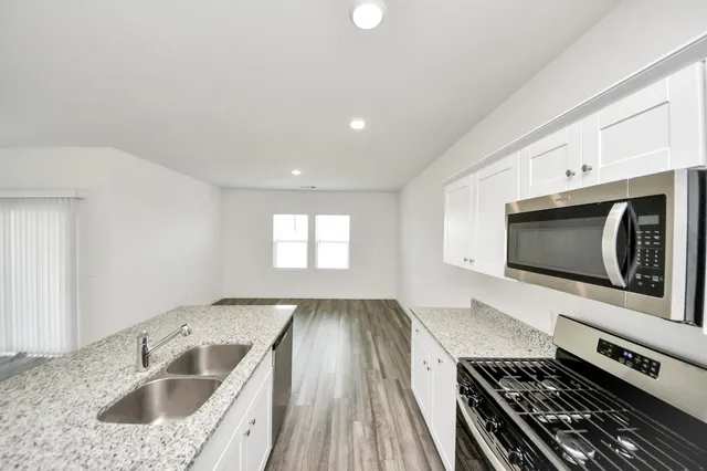 a kitchen with a sink stove and cabinets