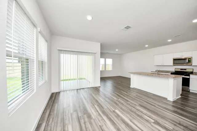 a view of kitchen with wooden floor and electronic appliances