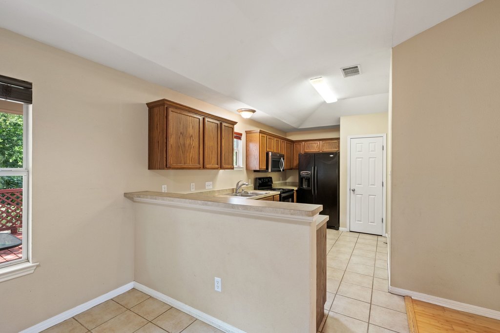 5208 Sioux Lane Austin, TX 78734 - Photo 10 of 35 A functional kitchen with warm wood cabinetry and a convenient breakfast bar.