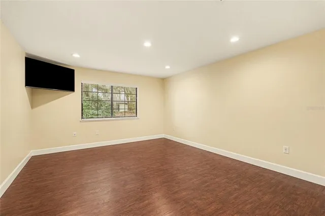 an empty room with windows and fireplace