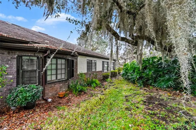 a view of a house with a yard and potted plants