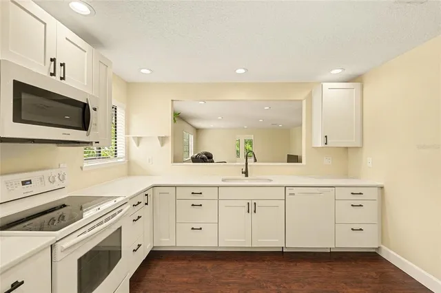 a kitchen with white cabinets sink and stainless steel appliances