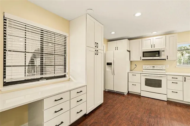 a kitchen with stainless steel appliances white cabinets and wooden floors
