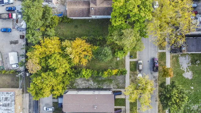an aerial view of residential house with outdoor space and trees all around