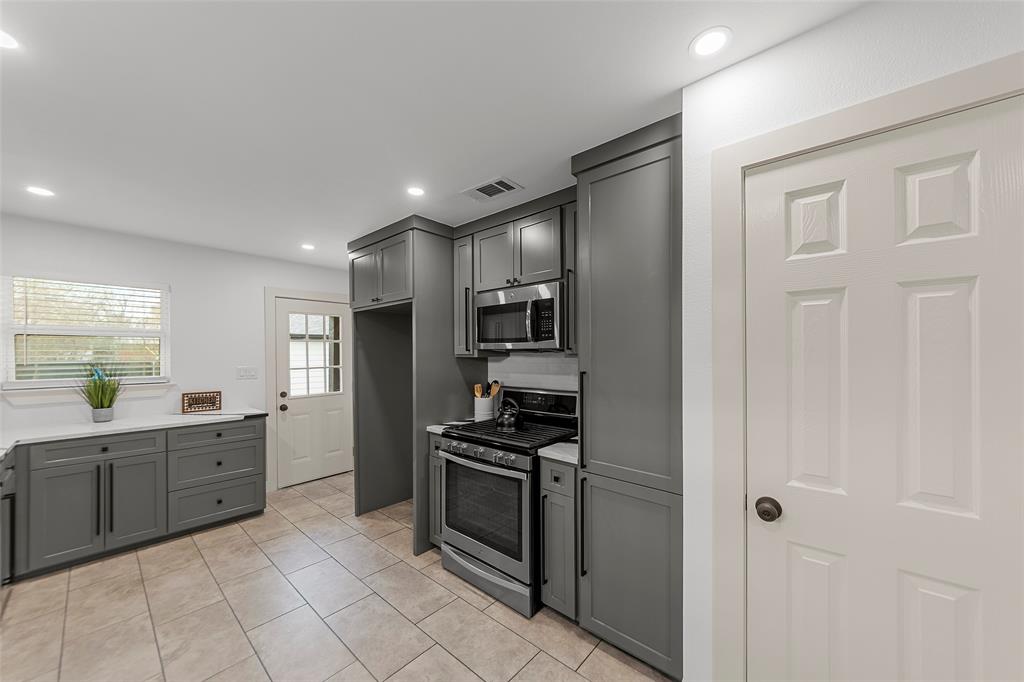 2945 Healey Drive Dallas, TX 75228 - Photo 9 of 38 a kitchen with stainless steel appliances a refrigerator sink and stove