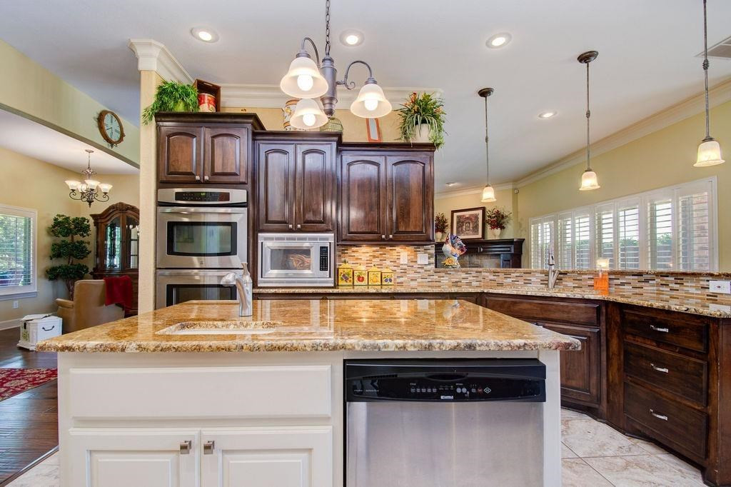 6506 15th Drive Lubbock, TX 79416 - Photo 12 of 42 a kitchen with stainless steel appliances granite countertop a stove and cabinets