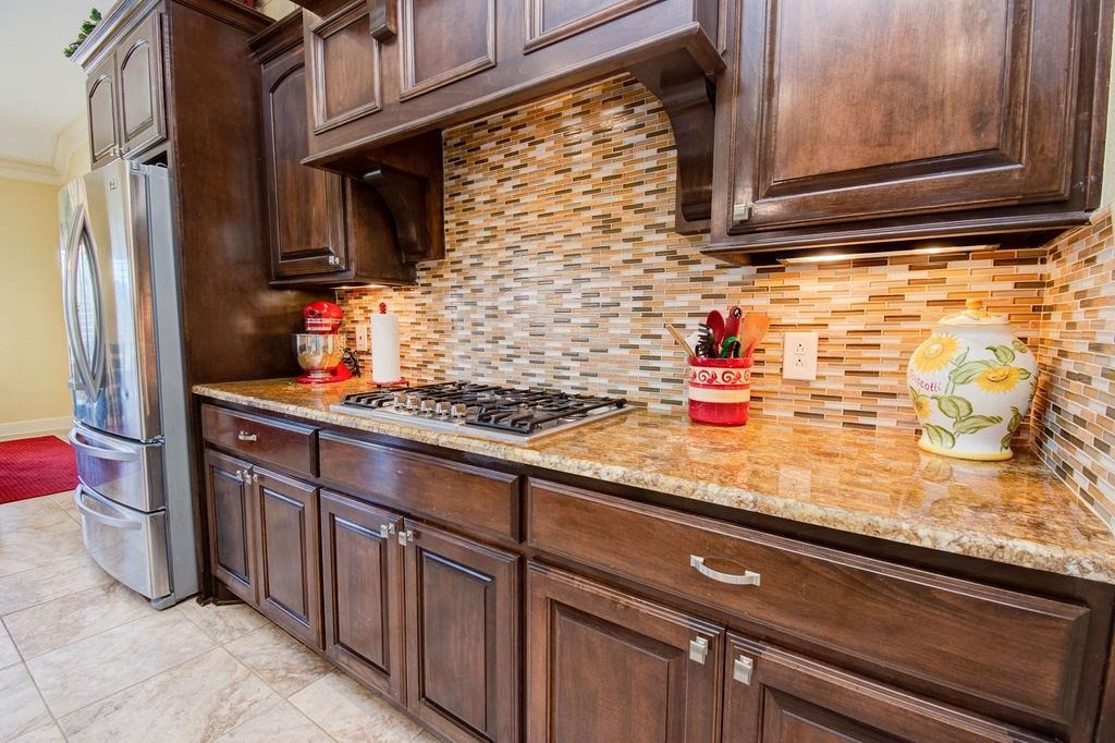 6506 15th Drive Lubbock, TX 79416 - Photo 14 of 42 a kitchen with granite countertop cabinets and black appliances