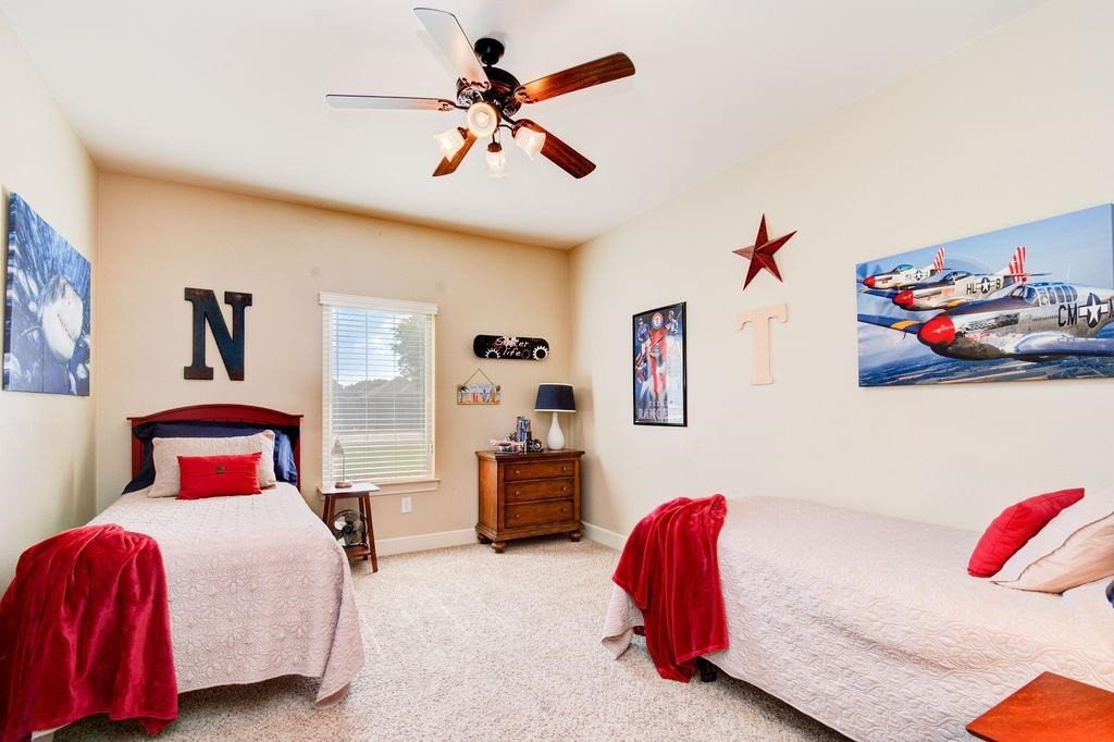 6506 15th Drive Lubbock, TX 79416 - Photo 28 of 42 a bedroom with a bed and a chandelier
