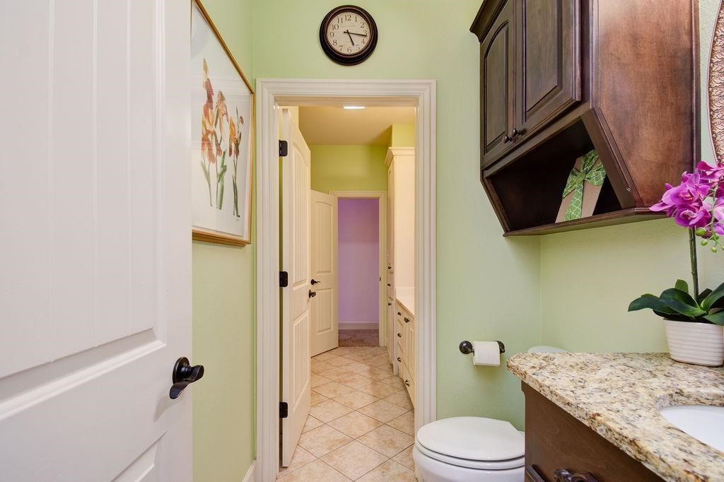 6506 15th Drive Lubbock, TX 79416 - Photo 32 of 42 a bathroom with a granite countertop sink toilet and shower