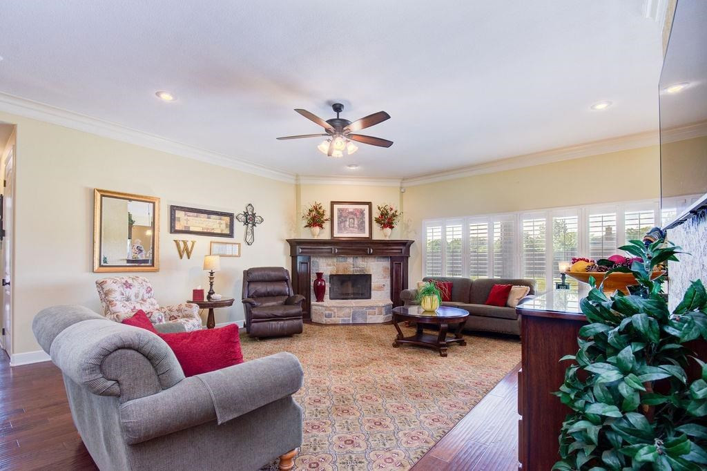 6506 15th Drive Lubbock, TX 79416 - Photo 9 of 42 a living room with furniture a fireplace and a potted plant