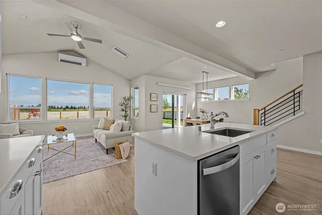 a kitchen with stainless steel appliances a refrigerator a stove a sink dishwasher and white countertops with wooden floor