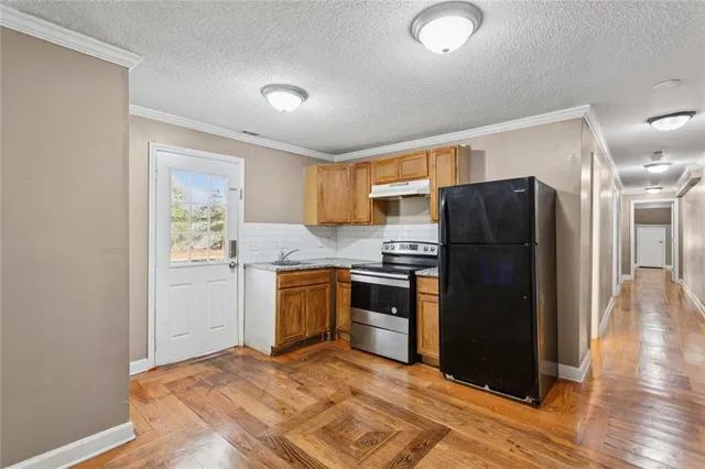 a kitchen with a refrigerator and a stove top oven