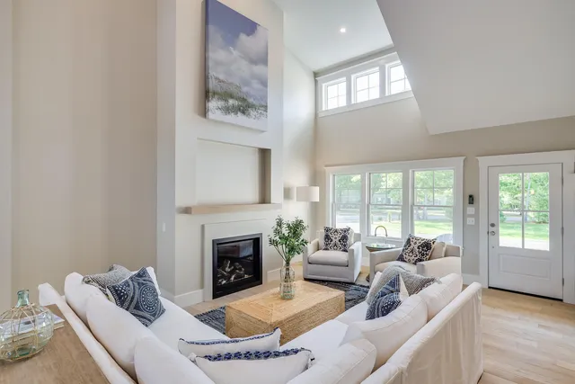 a living room with furniture a large window and a fireplace