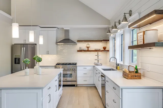 a kitchen with stainless steel appliances a sink stove and cabinets