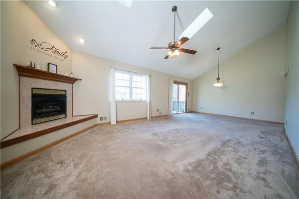 an empty room with windows and fireplace