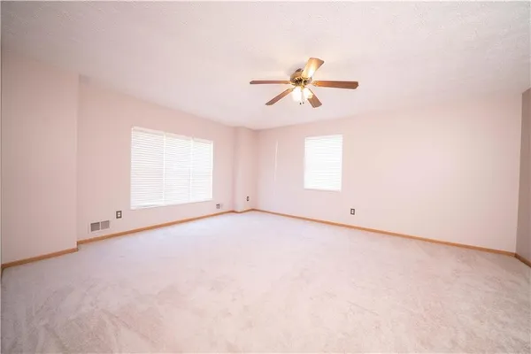 an empty room with a window and ceiling fan