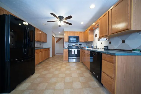 a kitchen with stainless steel appliances granite countertop a sink a stove and a refrigerator