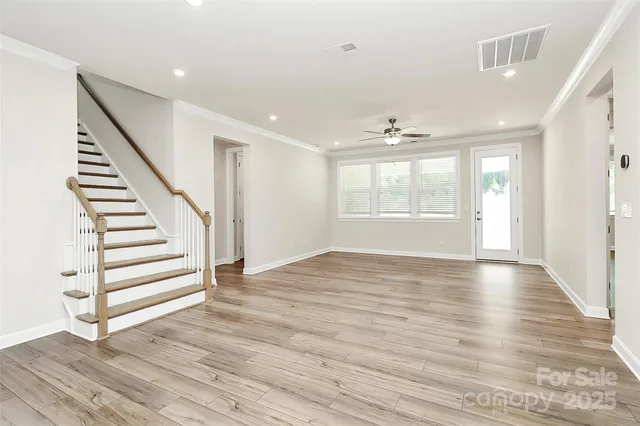 a view of a livingroom with a ceiling fan wooden floor and a ceiling fan