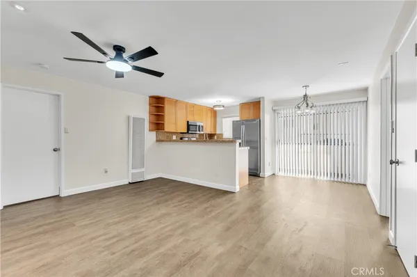 a view of a kitchen with wooden floor a ceiling fan a ceiling fan and windows