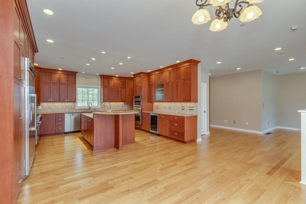 197 Dow Road Hollis, NH 03049 - Photo 4 of 38 a large kitchen with stainless steel appliances granite countertop a large counter top and a wooden floors