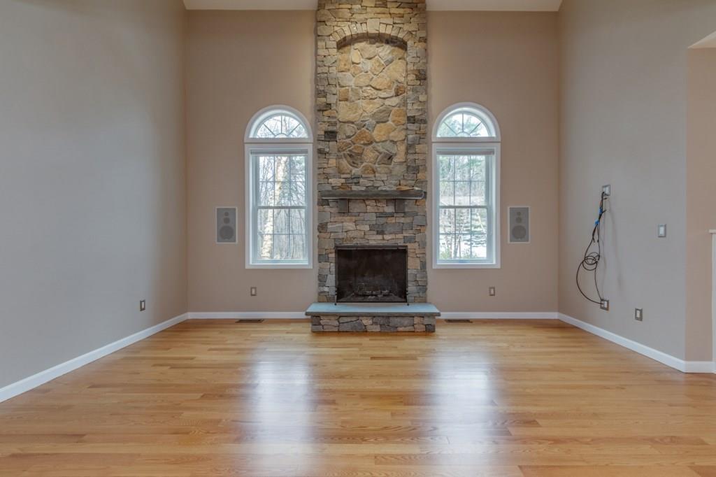 197 Dow Road Hollis, NH 03049 - Photo 9 of 38 a view of an empty room with wooden floor a fireplace and a window