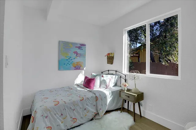 a bathroom with a toilet and a wooden floor