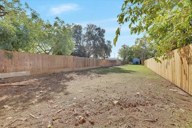 a view of backyard with wooden fence