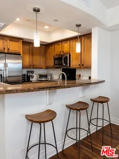 a kitchen with stainless steel appliances kitchen island a large window and cabinets