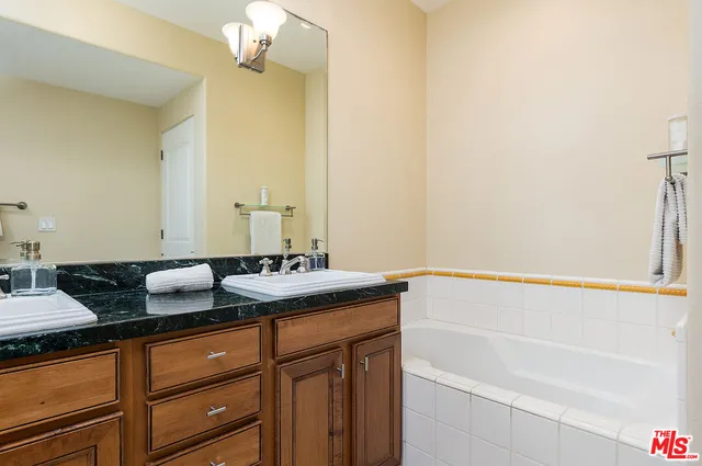 a bathroom with a granite countertop sink and a mirror